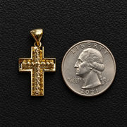 10K yellow gold diamond-cut cross pendant beside a U.S. quarter on black leather for size reference